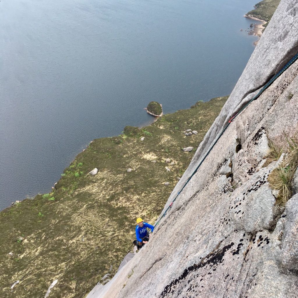 Climber high on the rock face